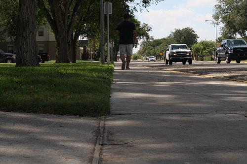 Residents walk along the side of the street because there is no sidewalk. Photo by Andres Diaz.