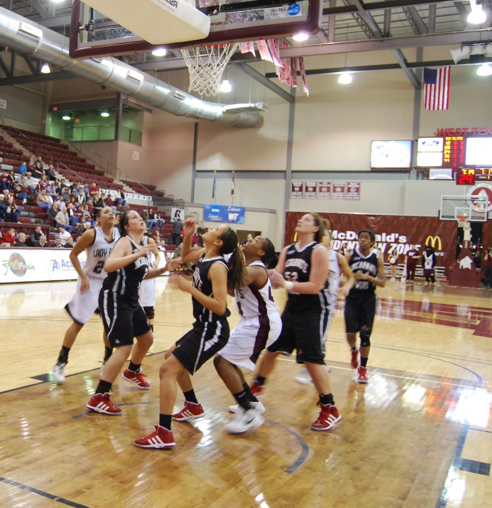 Both teams huddle under the net waiting for the ball. Photo by Melissa Bauer-Herzog.