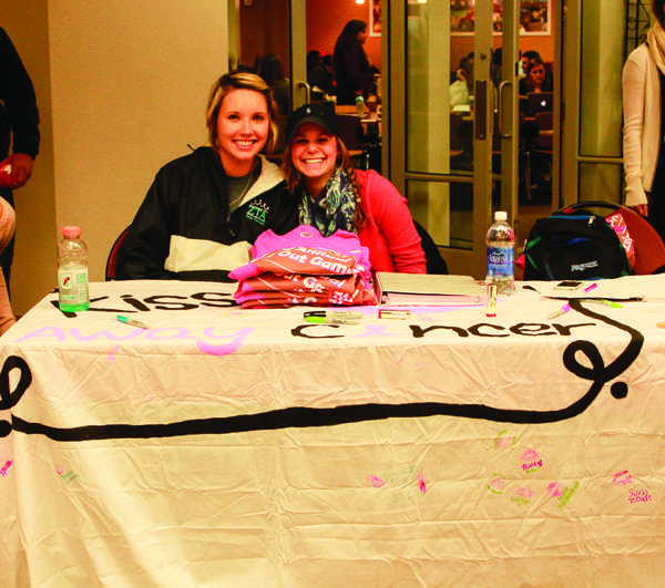 Hanna Withers and Alyssa Vermeulen of ZTA work the Kiss Away Cancer table. Photo by Natalia Molina.