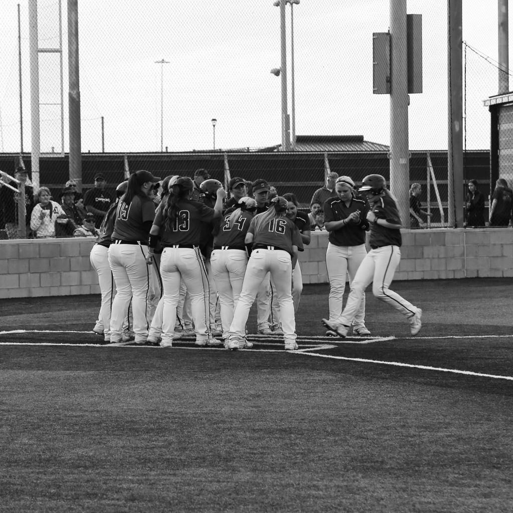 The team waits at  home plate after a Lady Buff homerun. 